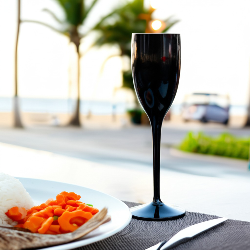 Copo de champanhe Liffe preto de 12 cl em uma mesa com comida